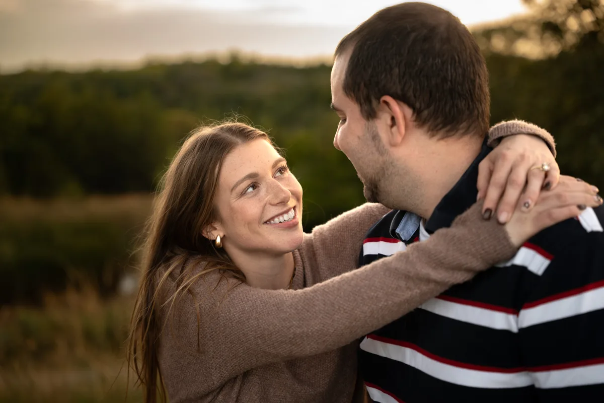 Engagement portrait at golden hour, her arms around his neck, minutes after she said yes at Mahoney State Park, Nebraska