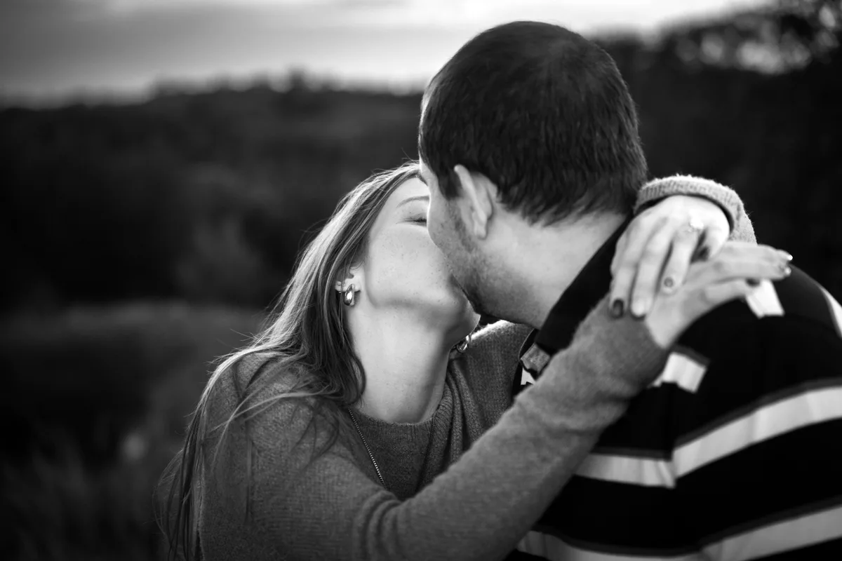 Black and white engagement portrait of a couple kissing at Mahoney State Park, Nebraska